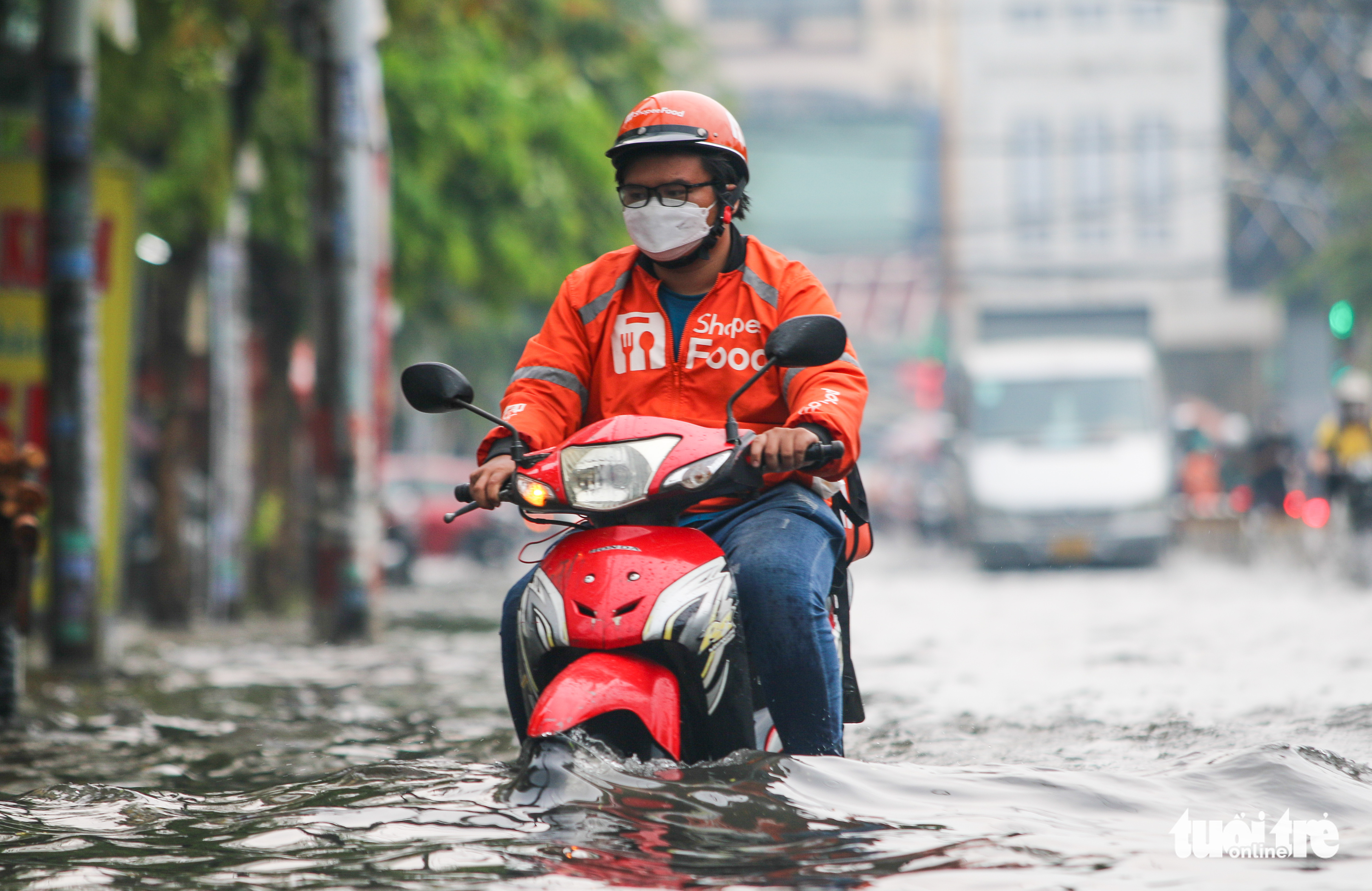 A delivery worker travels on a flooded road in Go Vap District, Ho Chi Minh City, April 16, 2022. Photo: Chau Tuan / Tuoi Tre