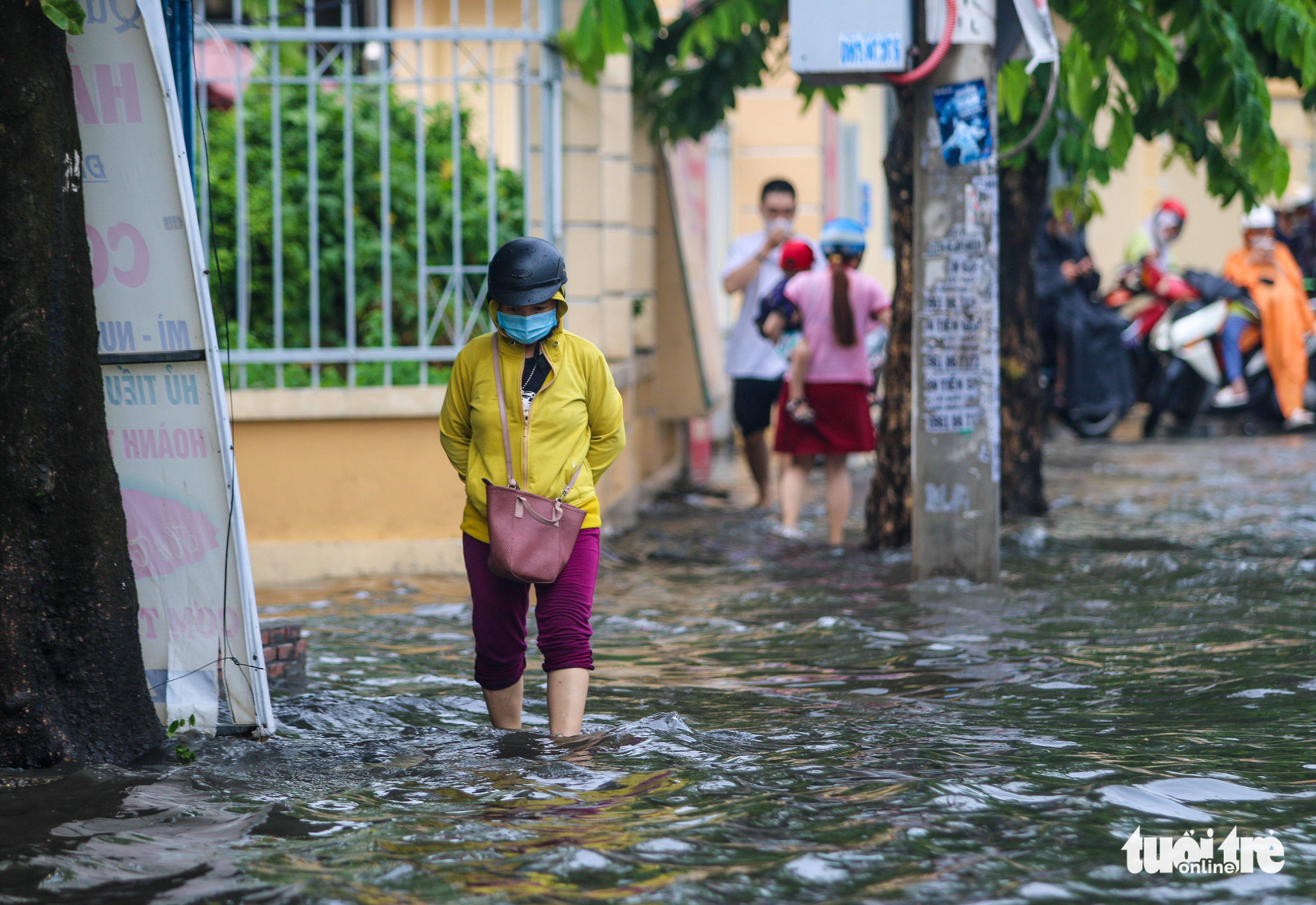 A woman walks on an inundated street in Go Vap District, Ho Chi Minh City, April 16, 2022. Photo: Chau Tuan / Tuoi Tre