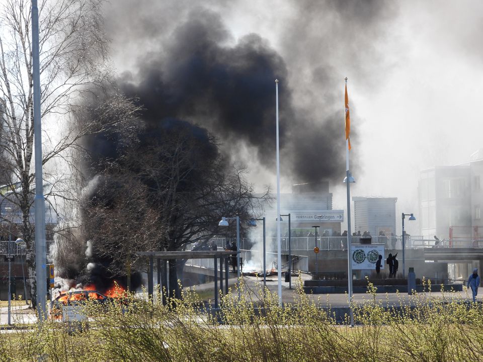 Smoke billows from a burning car during a riot ahead of a demonstration planned by Danish anti-Muslim politician Rasmus Paludan and his Stram Kurs party, which was to include a burning of the Muslim holy book Koran, in Navestad, Norrkoping, Sweden April 17, 2022, in this handout image obtained by Reuters on April 17, 2022. Ulf Wigh/Wighsnews/Handout via Reuters