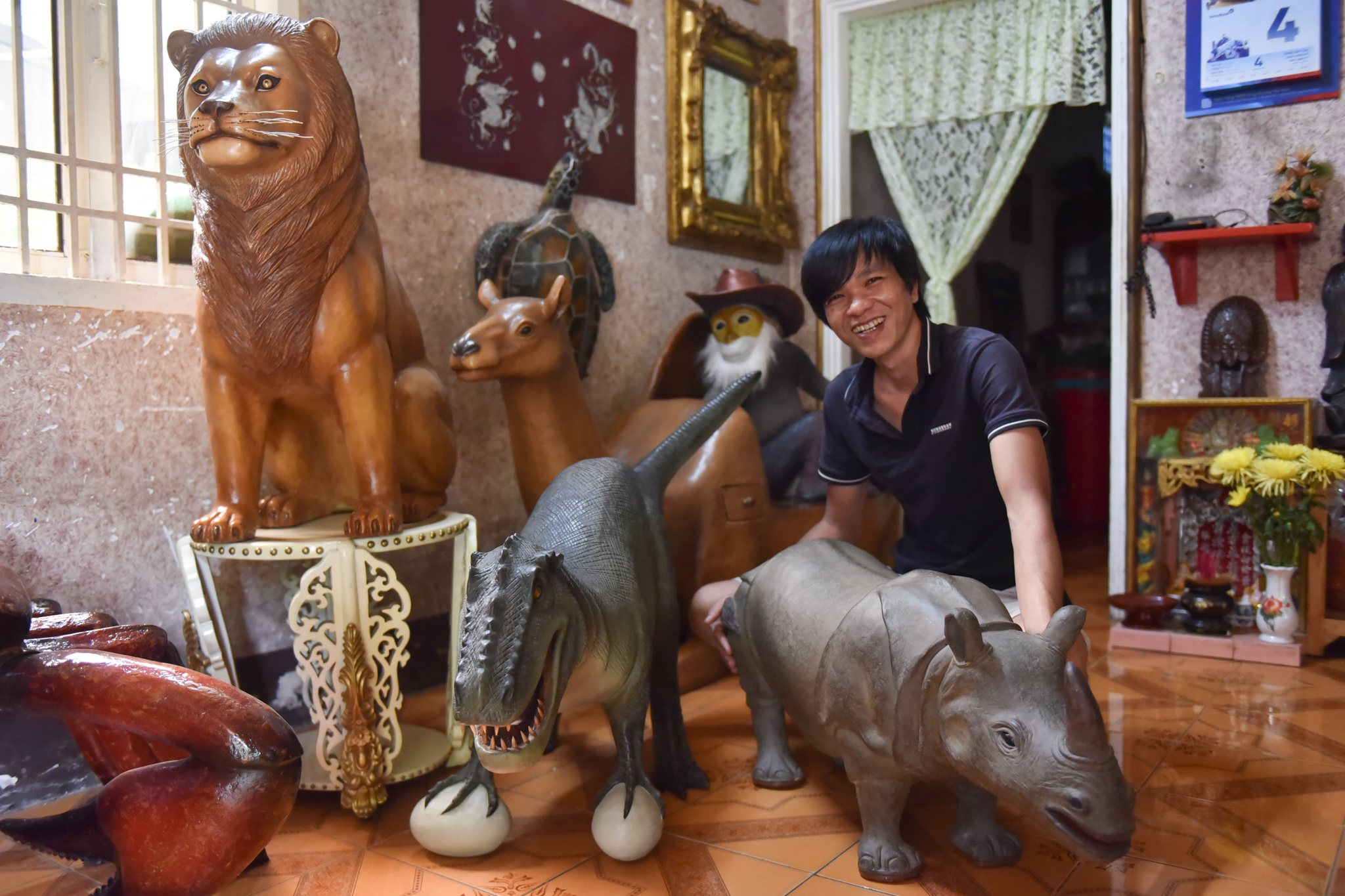 Nguyen Hoang Hai is seen with his sculptures of animals made from cardboard paper. Photo: Ngoc Phuong / Tuoi Tre News