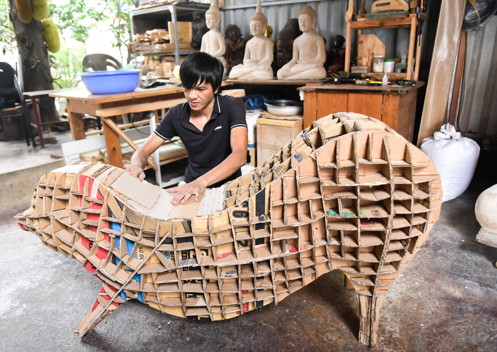 Hai is working on a frame for a sculpture from cardboard paper. Photo: Ngoc Phuong / Tuoi Tre News