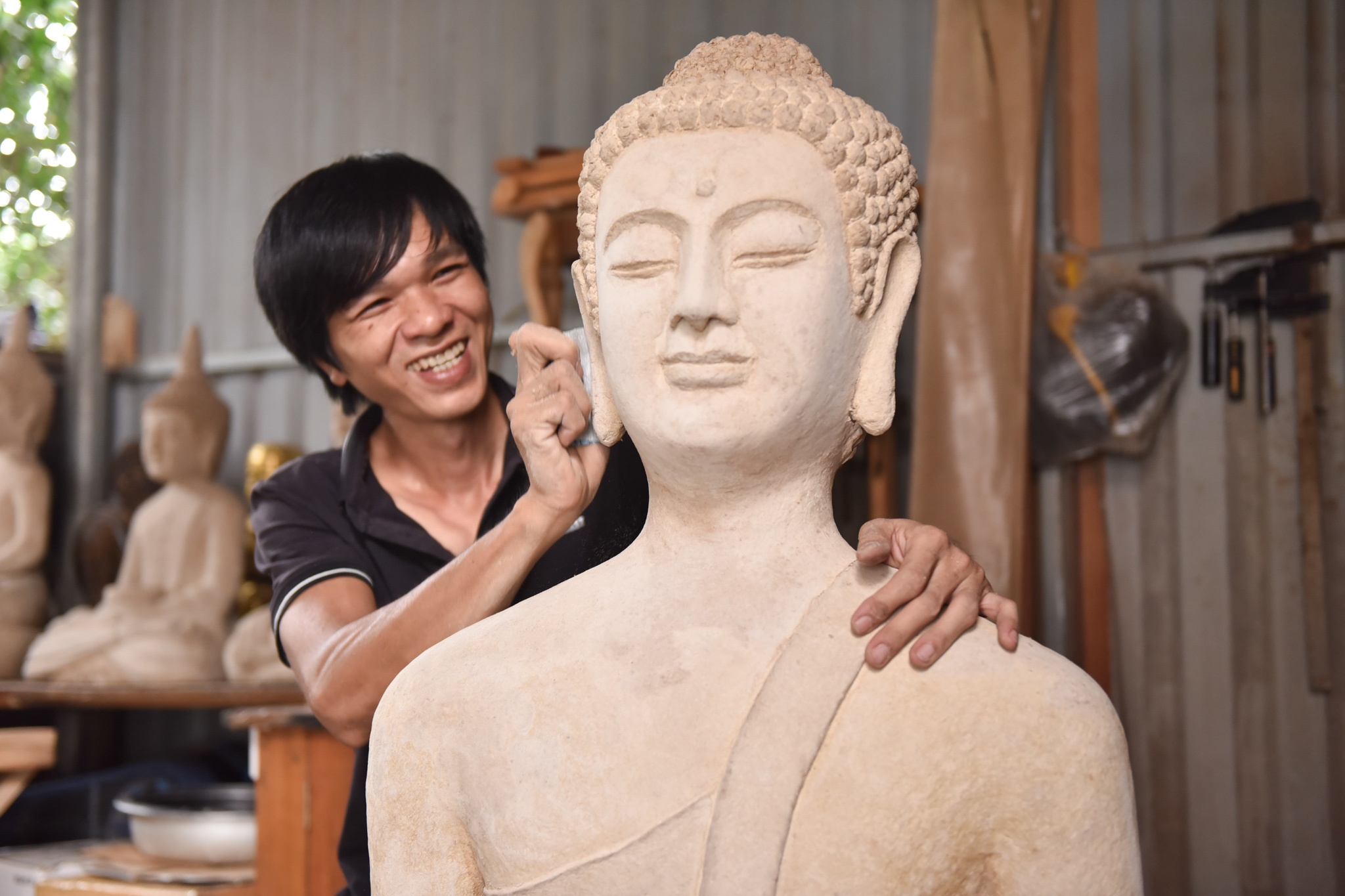 Nguyen Hoang Hai is working on a Buddha statue which sold for VND8 million (US$ 348.62). Photo: Ngoc Phuong / Tuoi Tre News