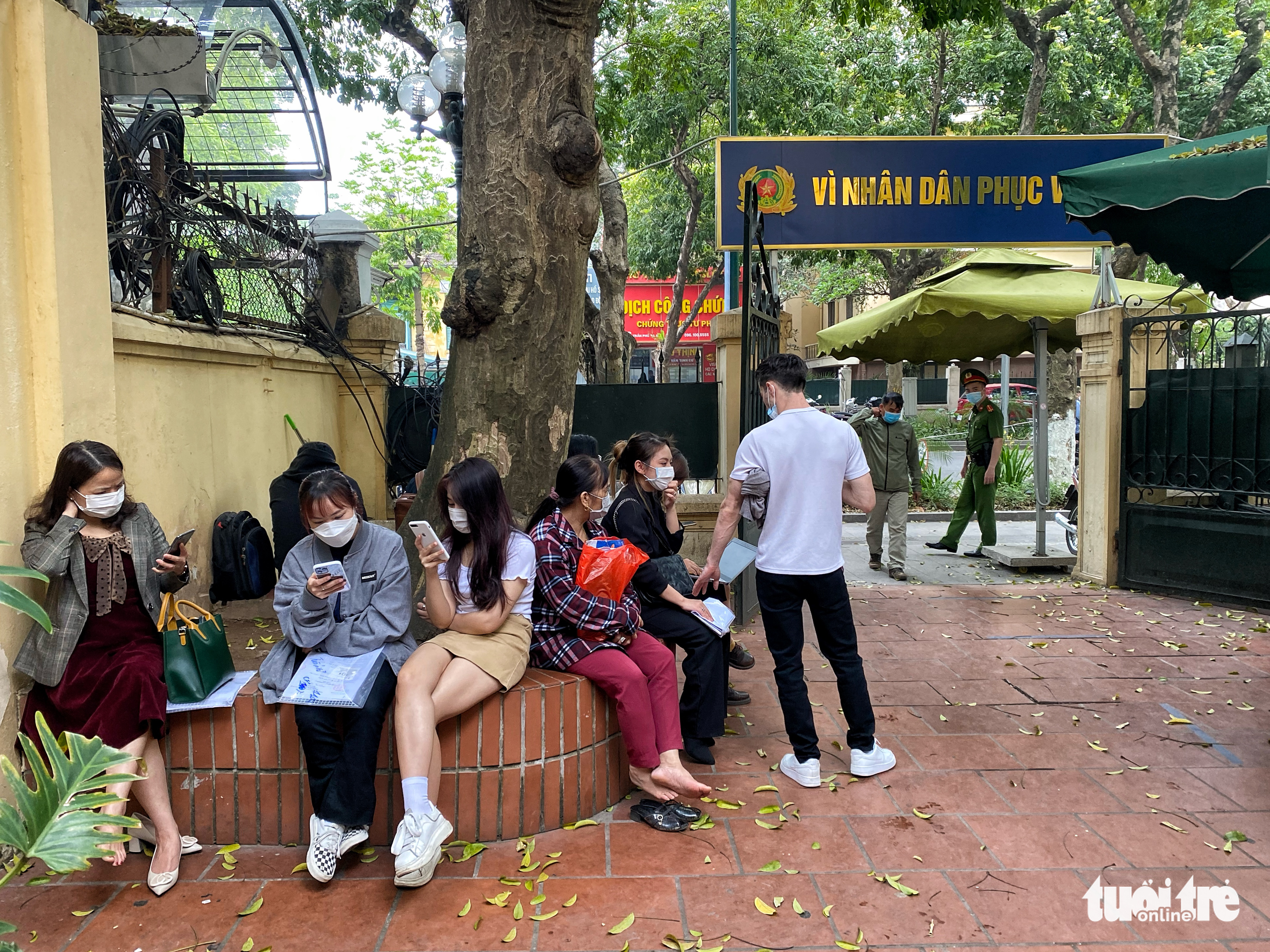 People wait outside of the passport application area after all seats are occupied at the Immigration Department headquarters in Hanoi, April 21, 2022. Photo: Pham Tuan / Tuoi Tre