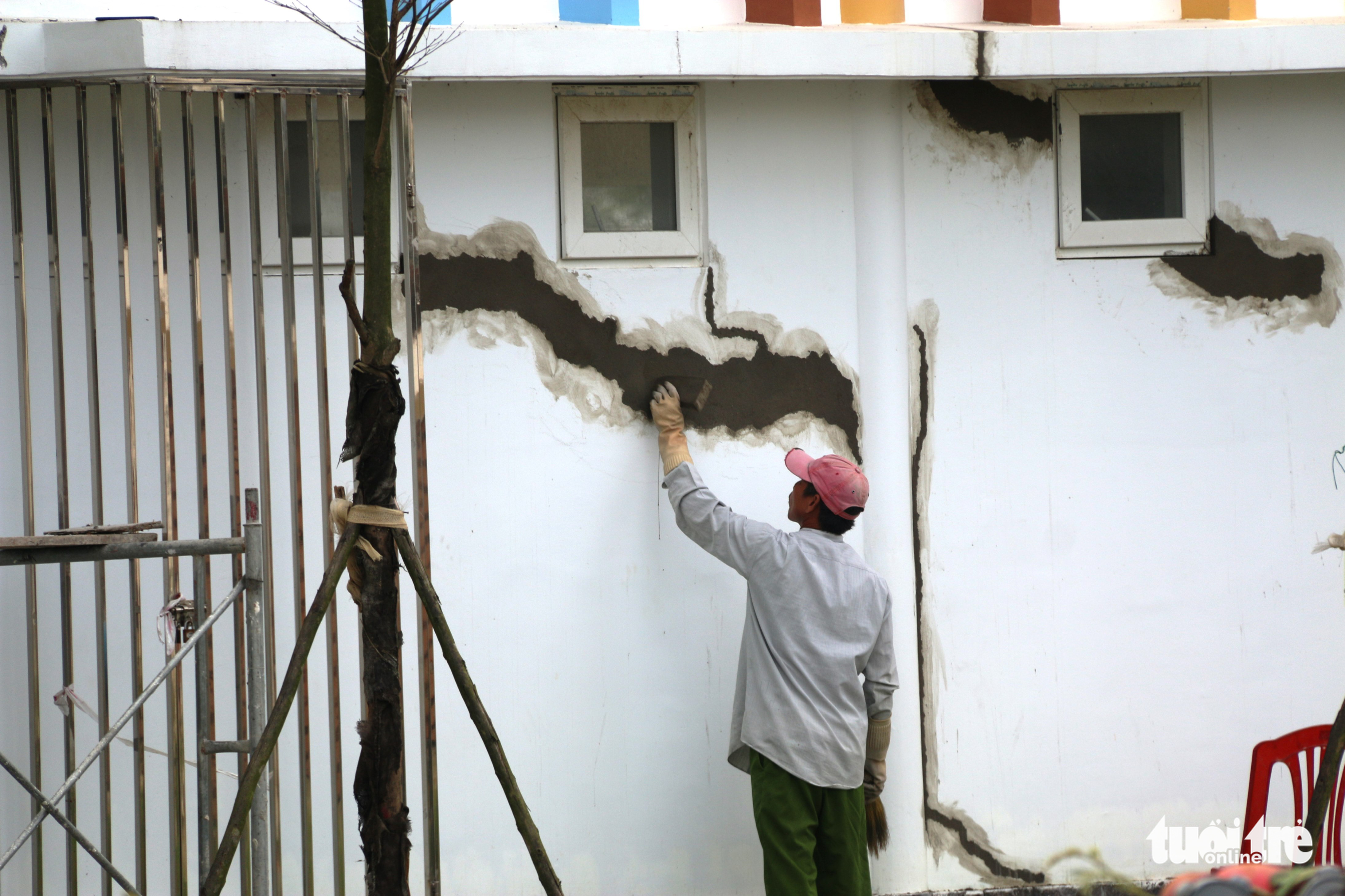 A worker fixes the cracks at Hoang Mai Kindergarten in Thua Thien-Hue Province, Vietnam. Photo: Nhat Linh / Tuoi Tre