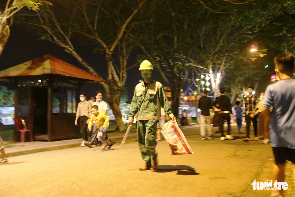This image shows an environmental worker assigned to collect waste from the pedestrian streets in the night street zone around the Hue Imperial Citadel City on April 22, 2022. Photo: Nhat Linh / Tuoi Tre