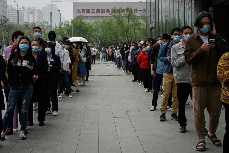 People wait in line to be tested for the Covid-19 coronavirus at a swab collection site in Beijing on April 25, 2022. Photo: AFP