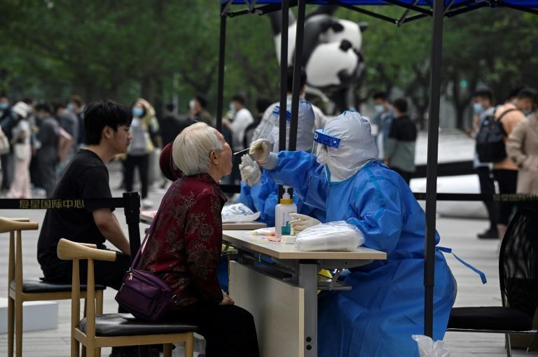 An elderly woman has a sample taken to be tested for the Covid-19 coronavirus at a swab collection site in Beijing on April 25, 2022. Photo: AFP