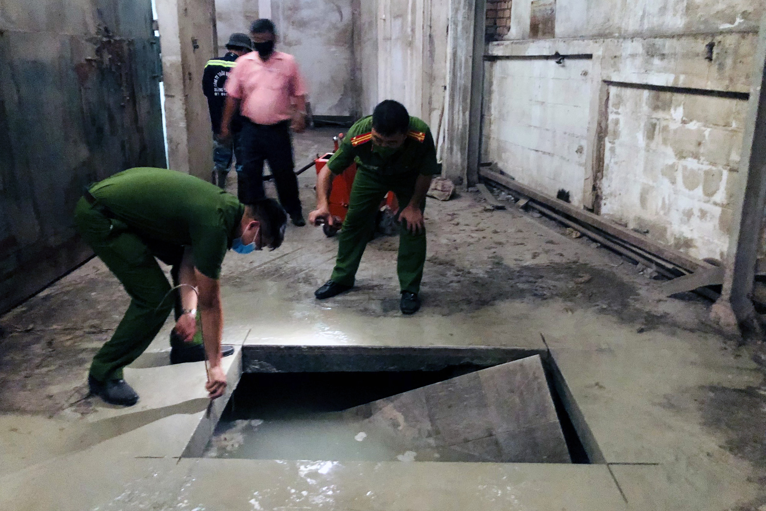 Police officers excavate a cellar containing untreated wastewater at a factory of Dien Quang Lamp JSC in Bien Hoa City, Dong Nai Province, April 24, 2022. Photo: B.A. / Tuoi Tre