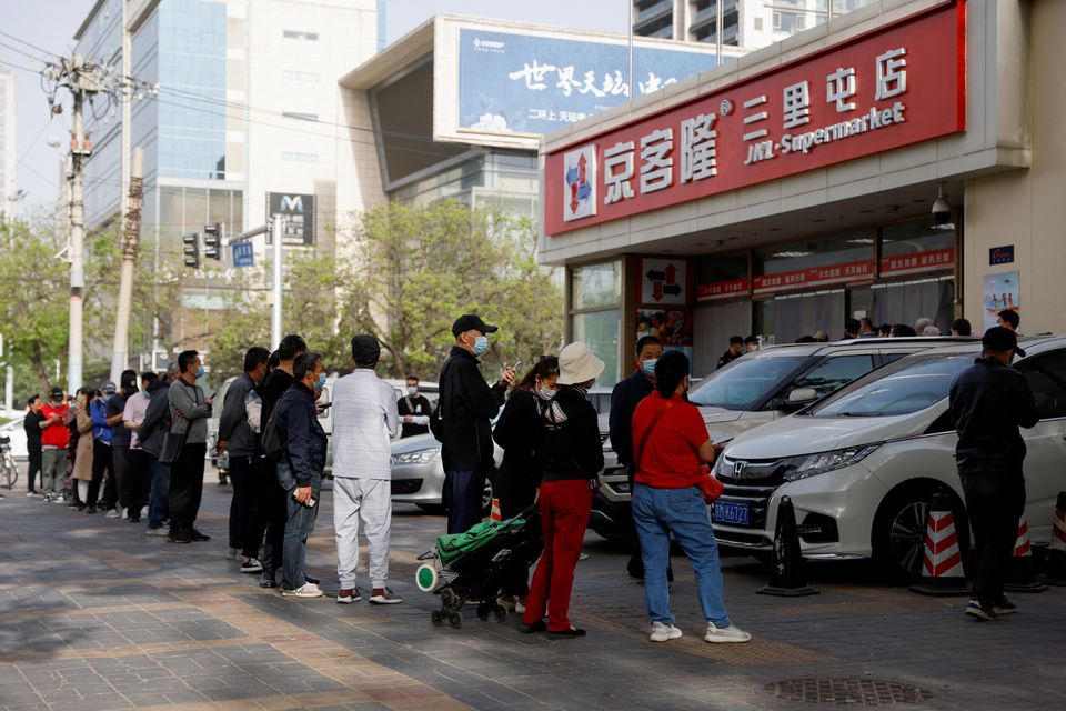 People wearing face masks wait in line to enter a supermarket ahead of its opening time following the coronavirus disease (COVID-19) outbreak, in Beijing, China April 26, 2022. Photo: Reuters