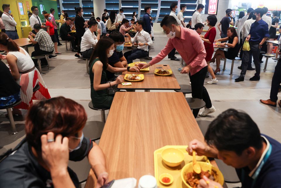 Office workers eat their lunch at the central business district on the first day free of coronavirus disease (COVID-19) restrictions in Singapore, April 26, 2022. Photo: Reuters