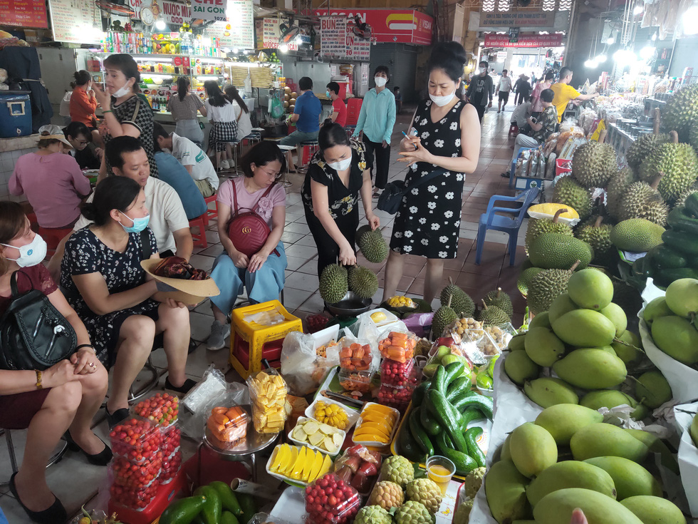 Ben Thanh Market has seen a surge in tourists from Hanoi City over the past one or two months. The photo shows a group of Hanoians buying fruits at the market last week to give them to their relatives and friends. Photo: N.Tri / Tuoi Tre