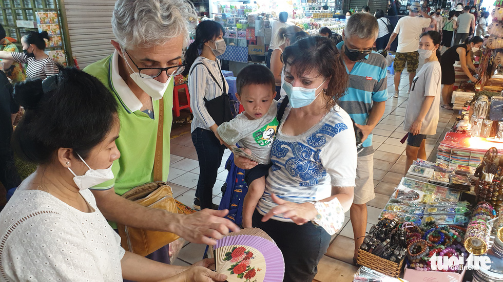 After several days of staying in Ho Chi Minh City, Michele and his wife, who are Italian nationals, come to Ben Thanh Market to buy numerous souvenirs. Photo: N.Tri / Tuoi Tre