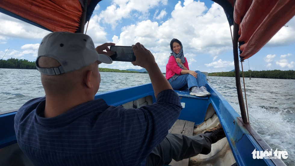 A man takes photo of his friend at Dong Ho Lagoon, Ha Tien City, Kien Giang Province. Photo: C.Cong / Tuoi Tre