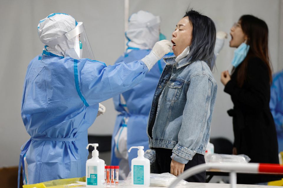 Medical workers in protective suits collect swabs samples from residents at a makeshift nucleic acid testing site amid a mass testing for the coronavirus disease (COVID-19) in Chaoyang district of Beijing, China April 27, 2022. Photo: Reuters