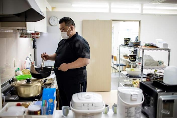 This picture taken on April 6, 2022 shows retired Japanese sumo wrestler and owner of the Hanasaki daycare centre, Keisuke Kamikawa, who competed under the name Wakatenro, preparing food for elderly people at the centre in Tokyo. Photo: AFP