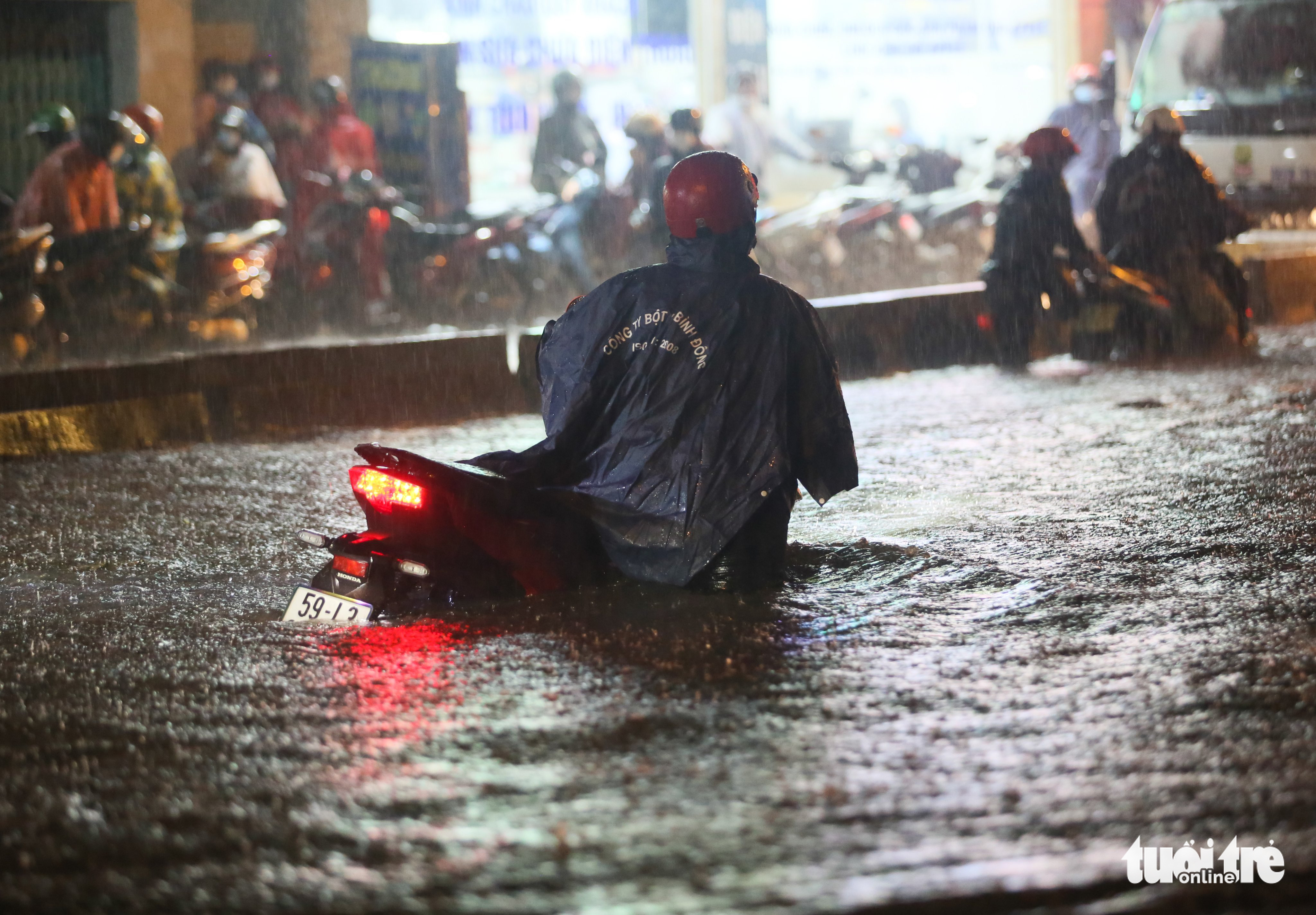 A motorcyclist wades through rainwater on a street in Thu Duc City, Ho Chi Minh City, April 29, 2022. Photo: Chau Tuan / Tuoi Tre