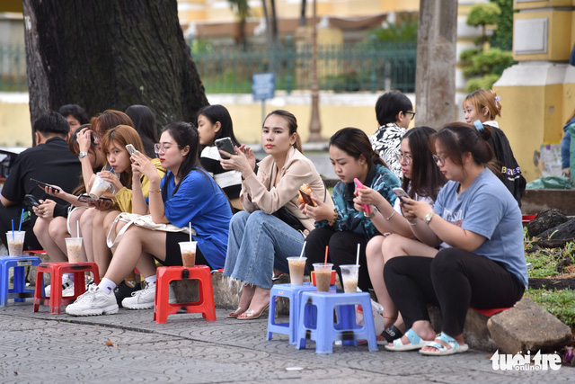 People enjoy street coffee n front of the Central Post Office in District 1, Ho Chi Minh City, April 30, 2022. Photo: Ngoc Phuong / Tuoi Tre