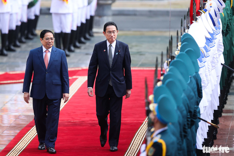 Vietnam’s Prime Minister Pham Minh Chinh (left) and visiting Japanese Prime Minister Kishida Fumio Kishida are seen reviewing the guard of honor in Hanoi on May 1, 2022. Photo: Nguyen Khanh / Tuoi Tre