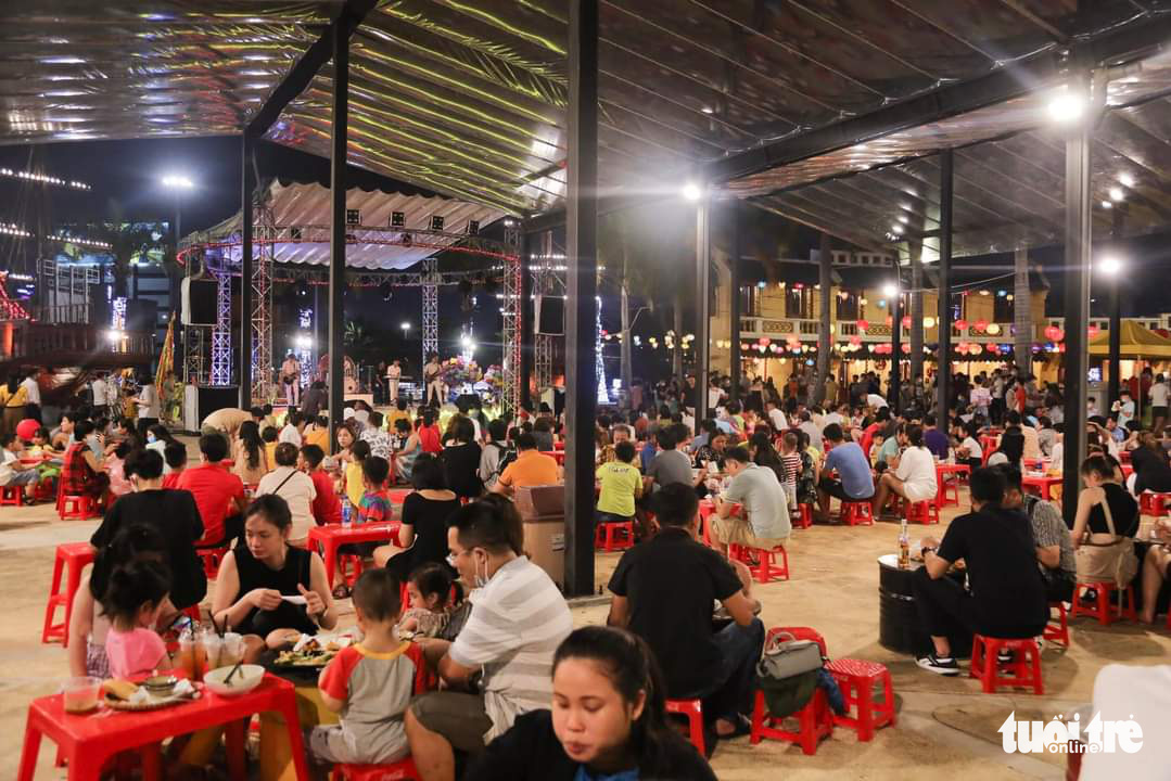 People eat food at a night market in Da Nang City, Vietnam. Photo: Truong Trung / Tuoi Tre