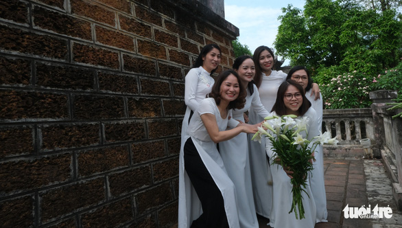 A group of visitors wearing ao dai (Vietnamese traditional costume) pose for a photo at the Son Tay ancient citadel. Photo: Ha Thanh / Tuoi Tre