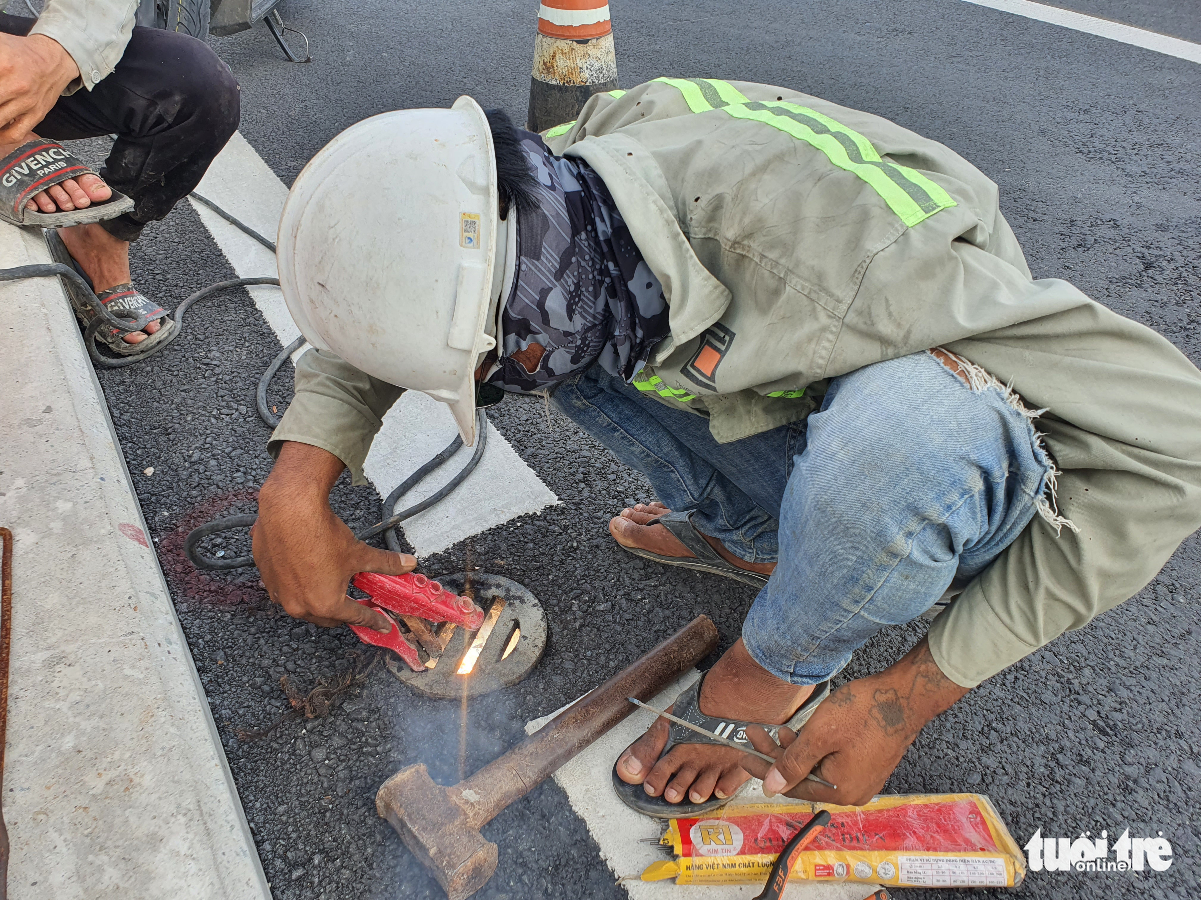 A workers welds the cover to prevent it from being stolen on Thu Thiem 2 Bridge in Ho Chi Minh City. Photo: Minh Hoa / Tuoi Tre