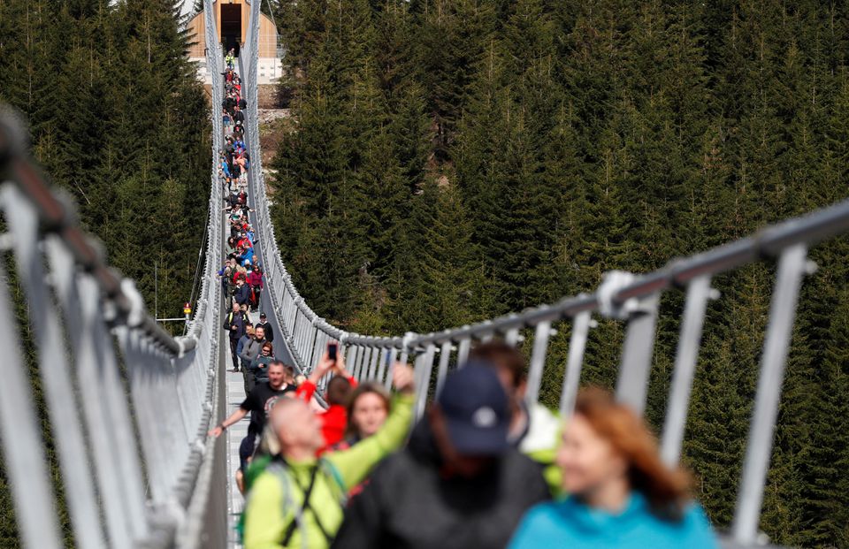 People walk across the newly-built world's longest suspension bridge after its official opening in the mountain resort of Dolni Morava, Czech Republic, May 13, 2022. Photo: Reuters