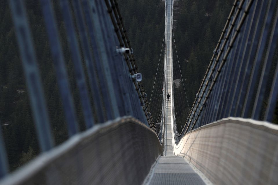 A staff member walks across the newly-built world's longest suspension bridge a day before its official opening in the mountain resort of Dolni Morava, Czech Republic, May 12, 2022. Picture taken May 12, 2022. Photo: Reuters