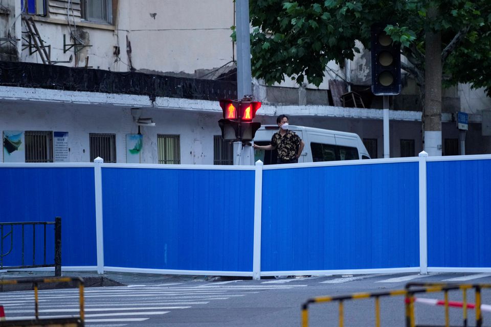 A man looks over the barriers of a closed street during lockdown amid the coronavirus disease (COVID-19) pandemic, in Shanghai, China, May 16, 2022. Photo: Reuters