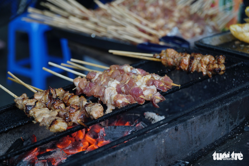 Grilled pork skewers are being prepared at a food vendor in Hanoi, Vietnam. Photo: Nguyen Hien / Tuoi Tre
