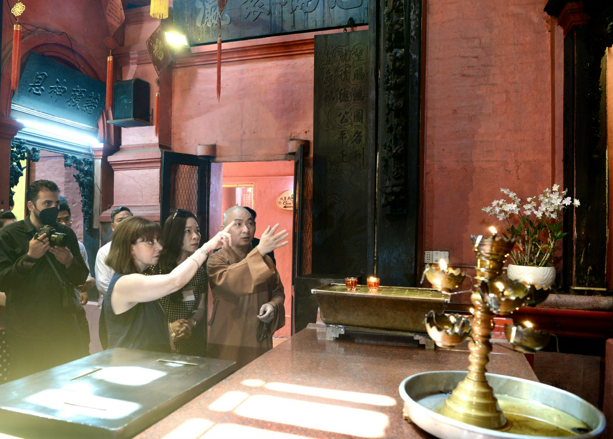 Greek President Katerina Sakellaropoulou asks a monk about the stories behind the statues at Ngoc Hoang Pagoda in District 1, Ho Chi Minh City, May 19, 2022. Photo: T.T.D. / Tuoi Tre