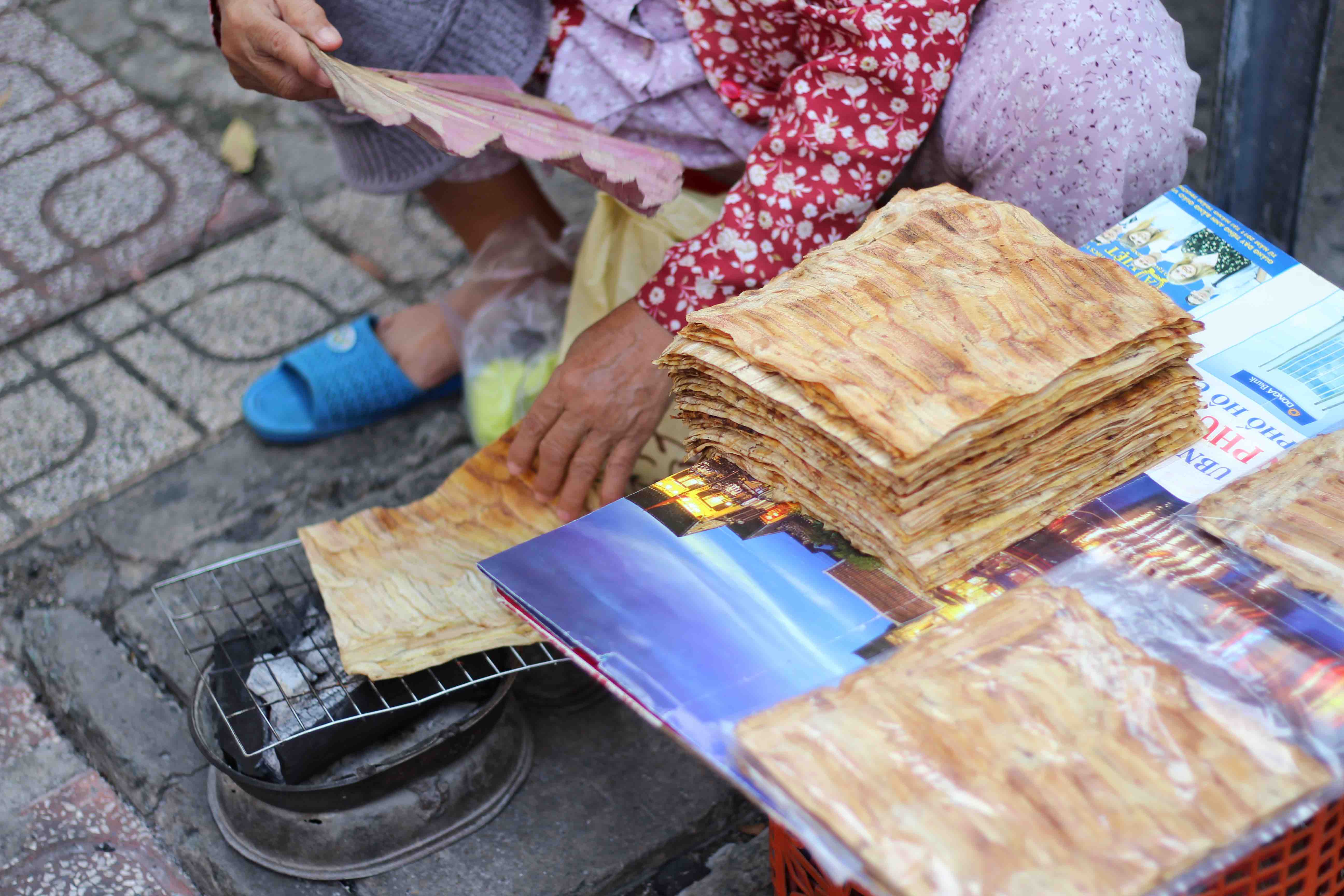 Nguyen Thi Loi grills banh chuoi nuong snack at her stall near Coopmart Nguyen Dinh Chieu supermarket in District 3, Ho Chi Minh City. Photo: Linh To / Tuoi Tre