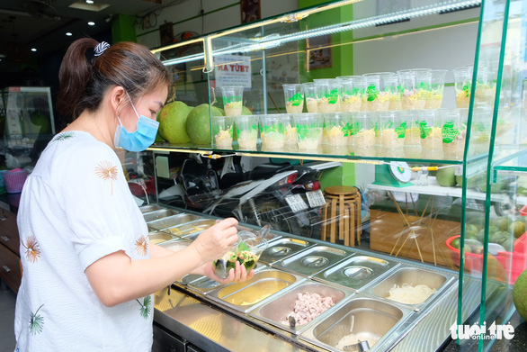 A staff is preparing orders for customers at a che (sweet desserts) 'quán' in Binh Thanh District, Ho Chi Minh City. Photo: Bong Mai / Tuoi Tre
