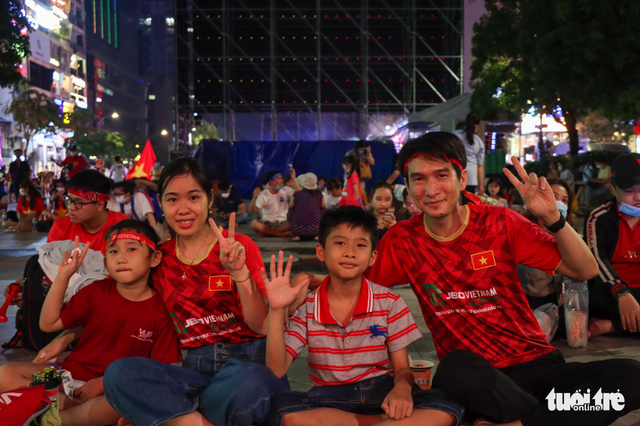 A family pose for a photo during the Vietnam - Malaysia men’s football semifinal at the 31st Southeast Asian (SEA) Games at the Nguyen Hue Pedestrian Street in District 1, Ho Chi Minh City, May 19, 2022. Photo: Thao Linh / Tuoi Tre