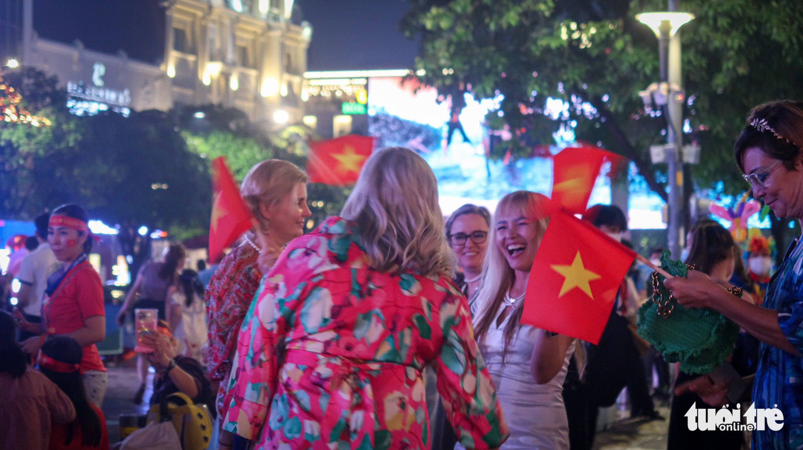 Foreigners celebrate Vietnam's win over Malaysia in the men’s football semifinal match at the 31st Southeast Asian (SEA) Games at the Nguyen Hue Pedestrian Street in District 1, Ho Chi Minh City, May 19, 2022. Photo: Thy Tho / Tuoi Tre