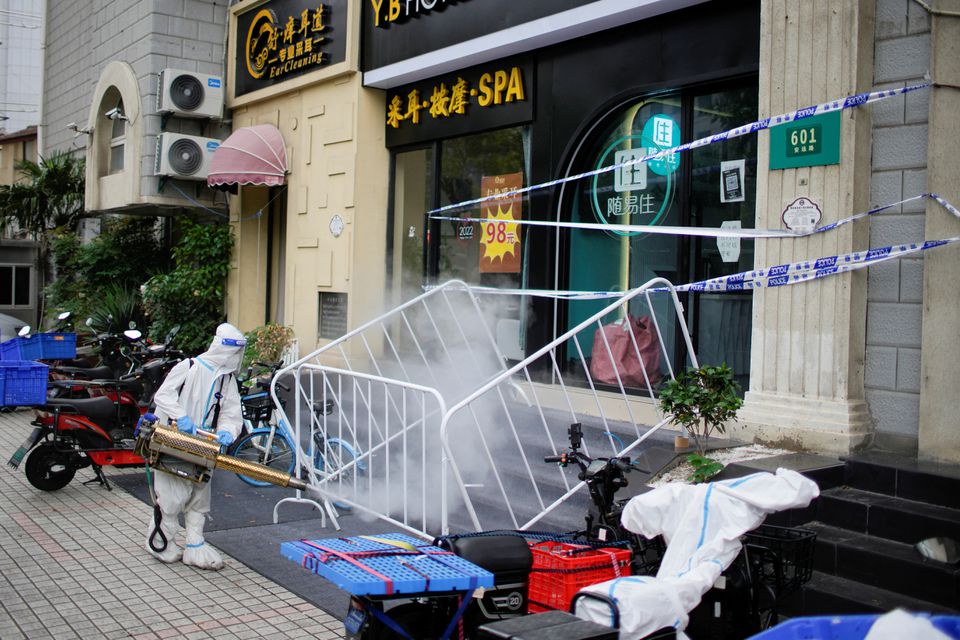 A worker in a protective suit disinfects a street during lockdown, amid the coronavirus disease (COVID-19) outbreak, in Shanghai, China, May 20, 2022. Photo: Reuters