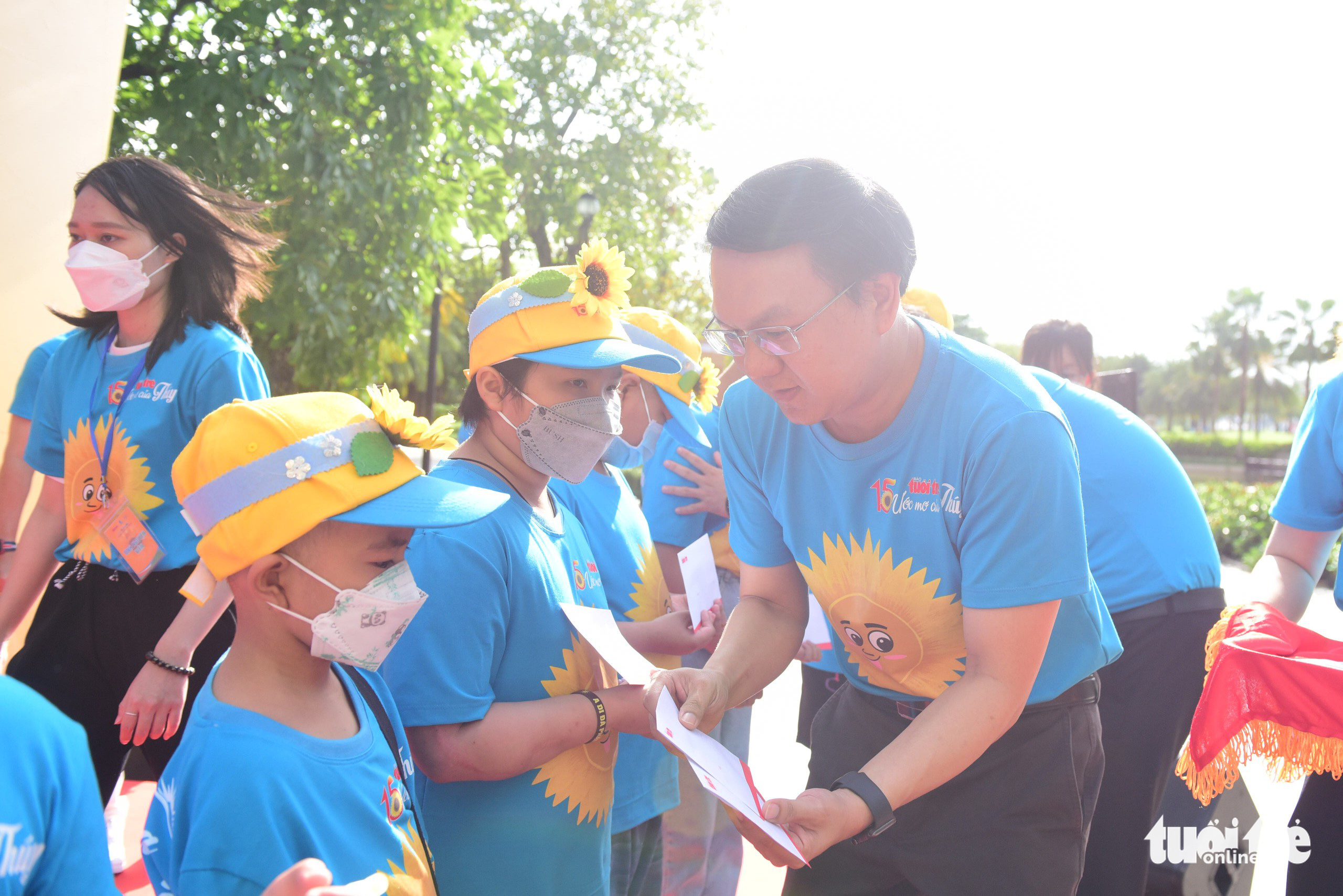 Director of the Ho Chi Minh City Department of Information and Communications Lam Dinh Thang hands scholarships to children with cancer in Binh Thanh District, Ho Chi Minh City, May 22, 2022. Photo: Duyen Phan / Tuoi Tre