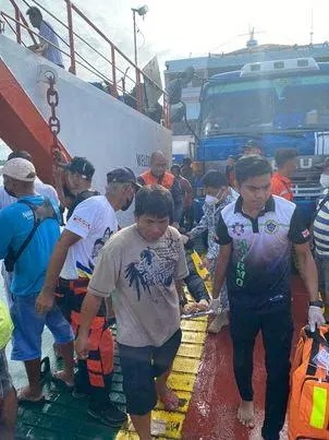 Rescuers carry a rescued passenger after a passenger vessel carrying more than 100 people caught fire near Real, Quezon province, May 23, 2022. Photo: Philippine Coast Guard/Handout via Reuters