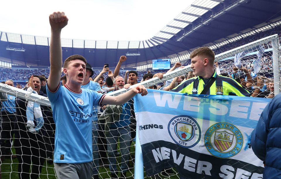 Soccer Football - Premier League - Manchester City v Aston Villa - Etihad Stadium, Manchester, Britain - May 22, 2022 Manchester City fans next to a broken goal post as they celebrate on the pitch after winning the Premier League. Photo: Reuters