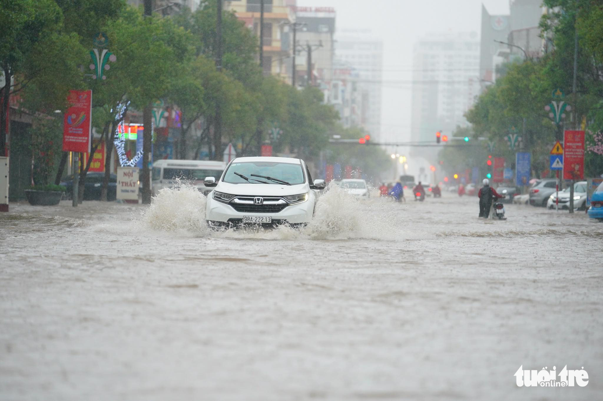 A car travels on a flooded street in Bac Giang Province, Vietnam, May 24, 2022. Photo: Ken / Tuoi Tre