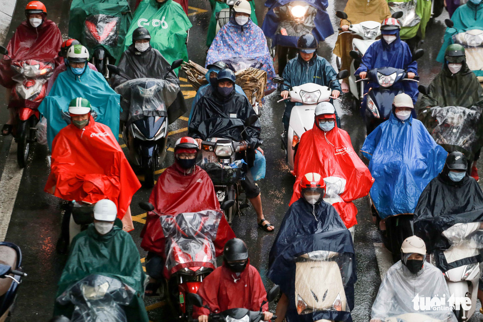 People are seen on their motorbikes in a traffic jam under the rain on a Hanoi street on May 24, 2022 in this image. Photo: Chi Tue / Tuoi Tre