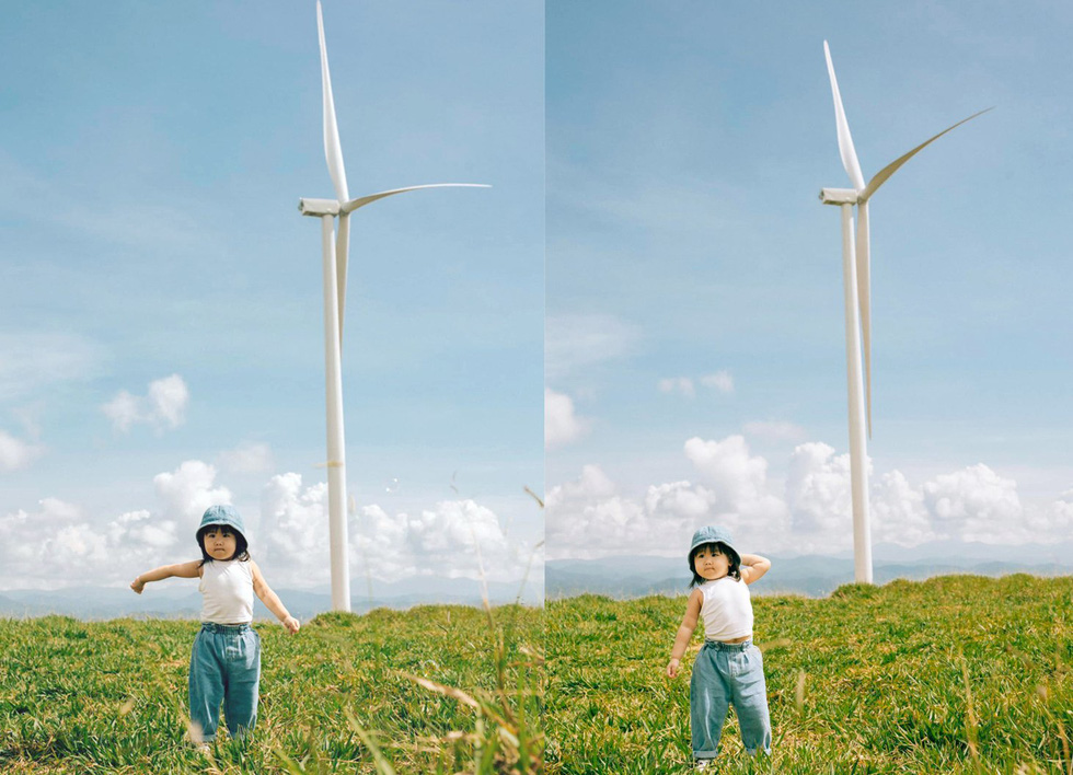 A child poses against the blue sky and a wind turbine at Cau Dat Tea Farm in Da Lat City's Xuan Truong Commune. Photo: Nguyen Hien / Tuoi Tre