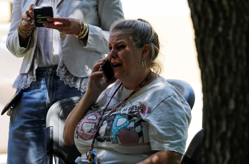 A woman reacts while talking on the phone outside the Ssgt Willie de Leon Civic Center, where students had been transported from Robb Elementary School to be picked up after a suspected shooting, in Uvalde, Texas, U.S. May 24, 2022. Photo: Reuters