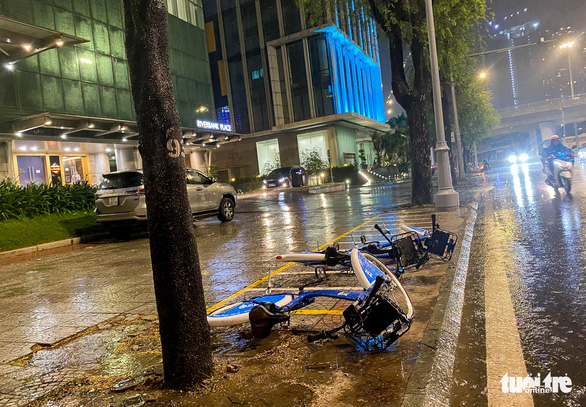 Public bikes lay on a sidewalk in District 1, Ho Chi Minh City in the rain on May 26, 2022. Photo: Chau Tuan / Tuoi Tre