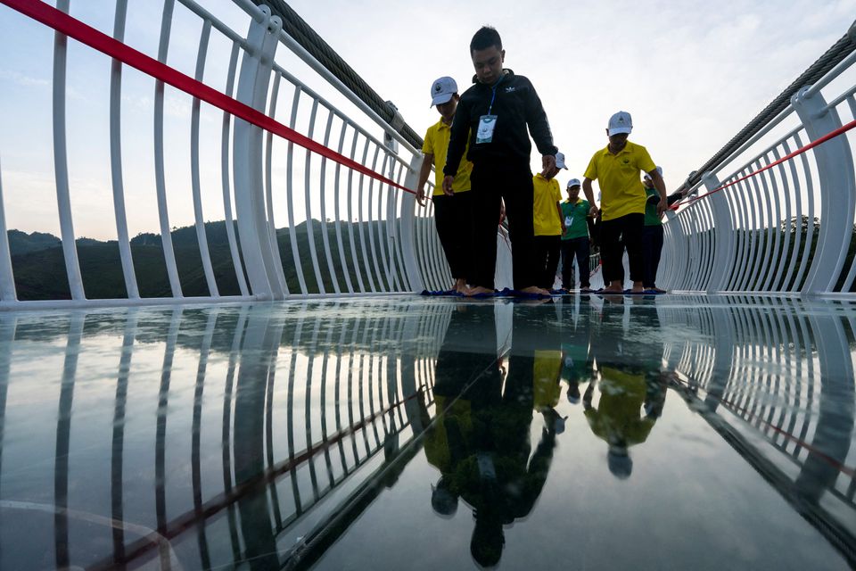 Workers clean the Bach Long glass bridge ahead of the opening ceremony at Moc Chau district in Son La province, Vietnam, May 28, 2022. Picture taken May 28, 2022. Photo: Reuters