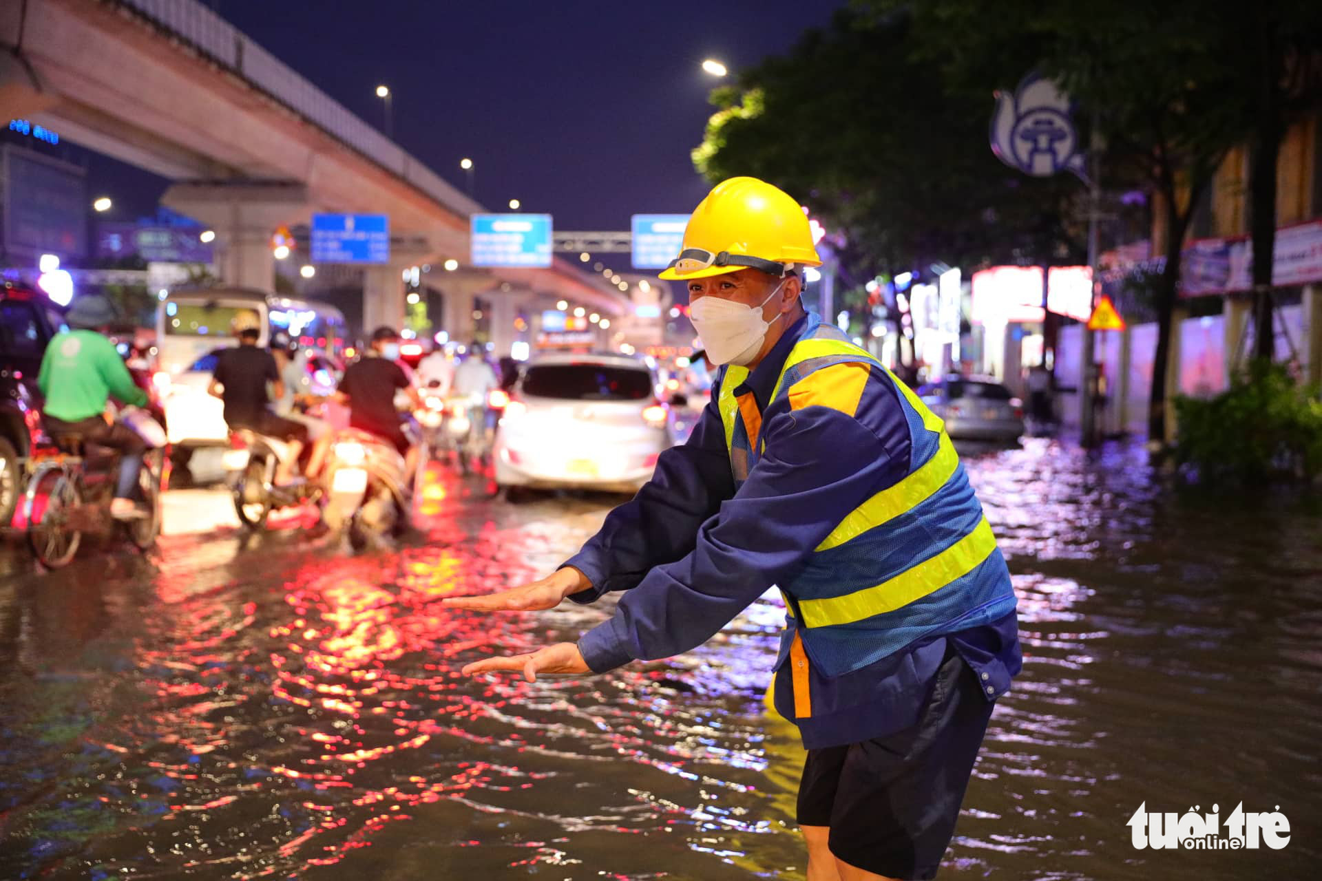 A drainage worker works on a flooded street in Hanoi, May 29, 2022. Photo: Lam Ngoc / Tuoi Tre