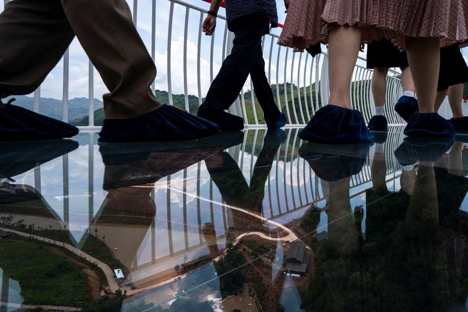 People walk on the Bach Long glass bridge during the opening ceremony at Moc Chau district in Son La province, Vietnam, May 28, 2022. Picture taken May 28, 2022. Photo: Reuters