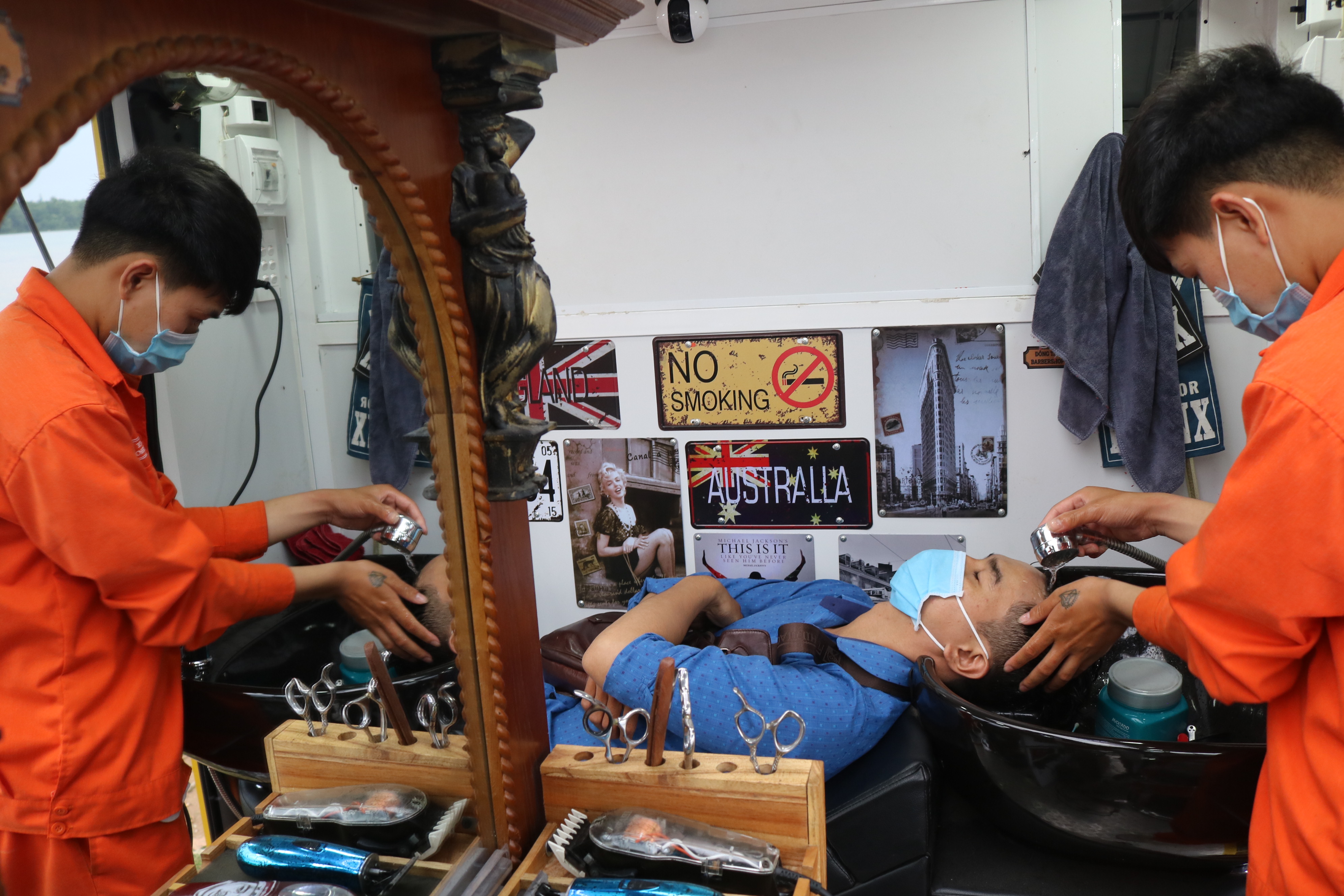 A barber washes a customer's hair at Dong Tay mobile barbershop in District 2, Ho Chi Minh City. Photo: Hoang An / Tuoi Tre