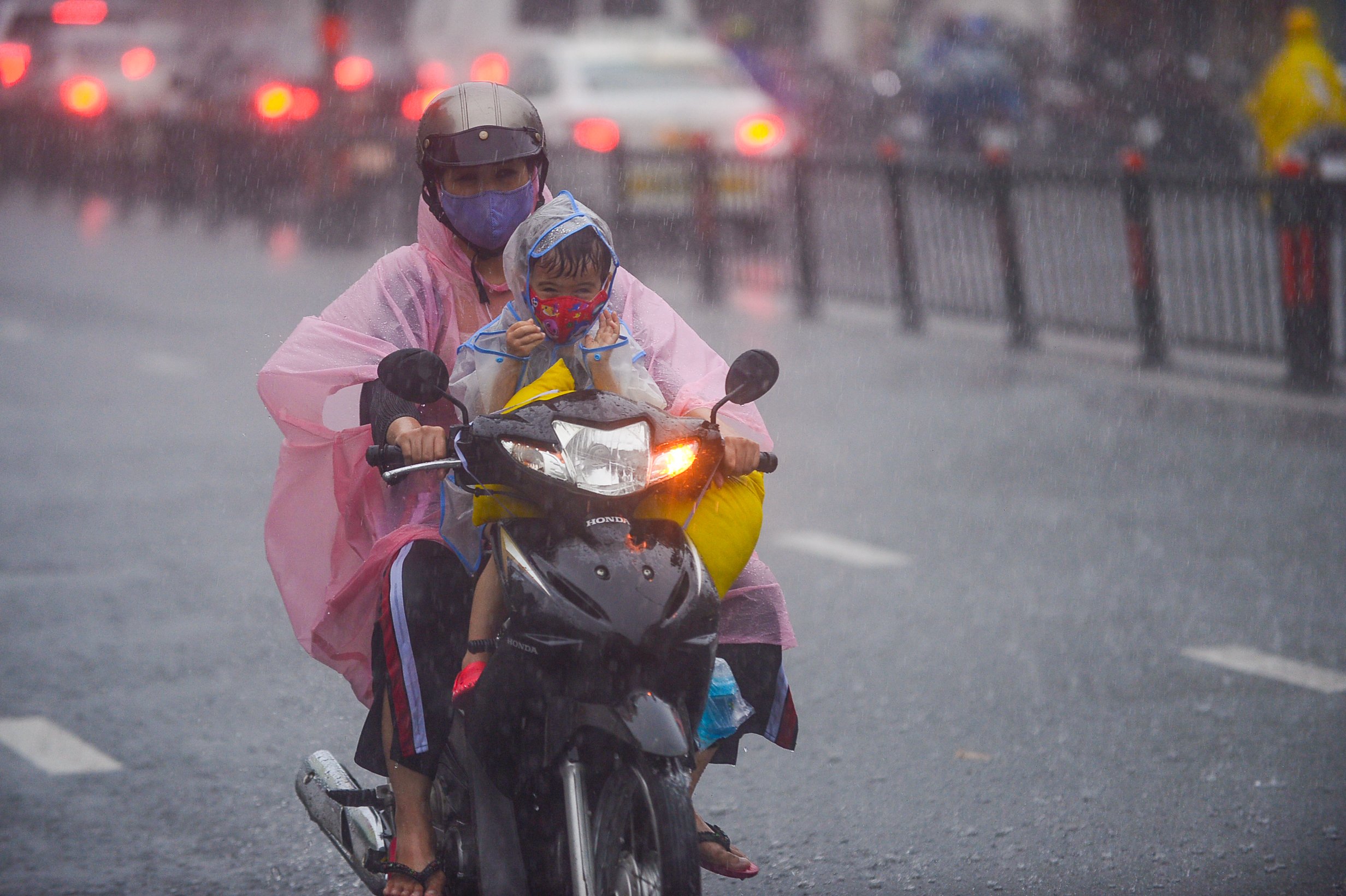 A woman and her child travel during a heavy downpour in Ho Chi Minh City, June 2, 2022. Photo: Quang Dinh / Tuoi Tre