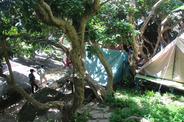 Visitors are seen camping under the ancient longan trees at Lai Son Island, Kien Hai Island District, Kien Giang Province. Photo: C.Cong / Tuoi Tre