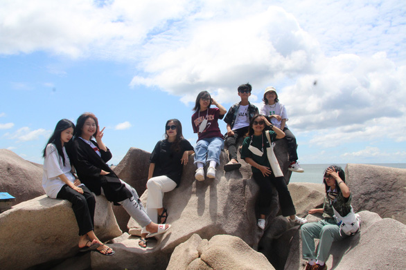 A group of tourists poses for a photo with the beachrock at Lai Son Island, Kien Hai Island District, Kien Giang Province. Photo: C.Cong / Tuoi Tre